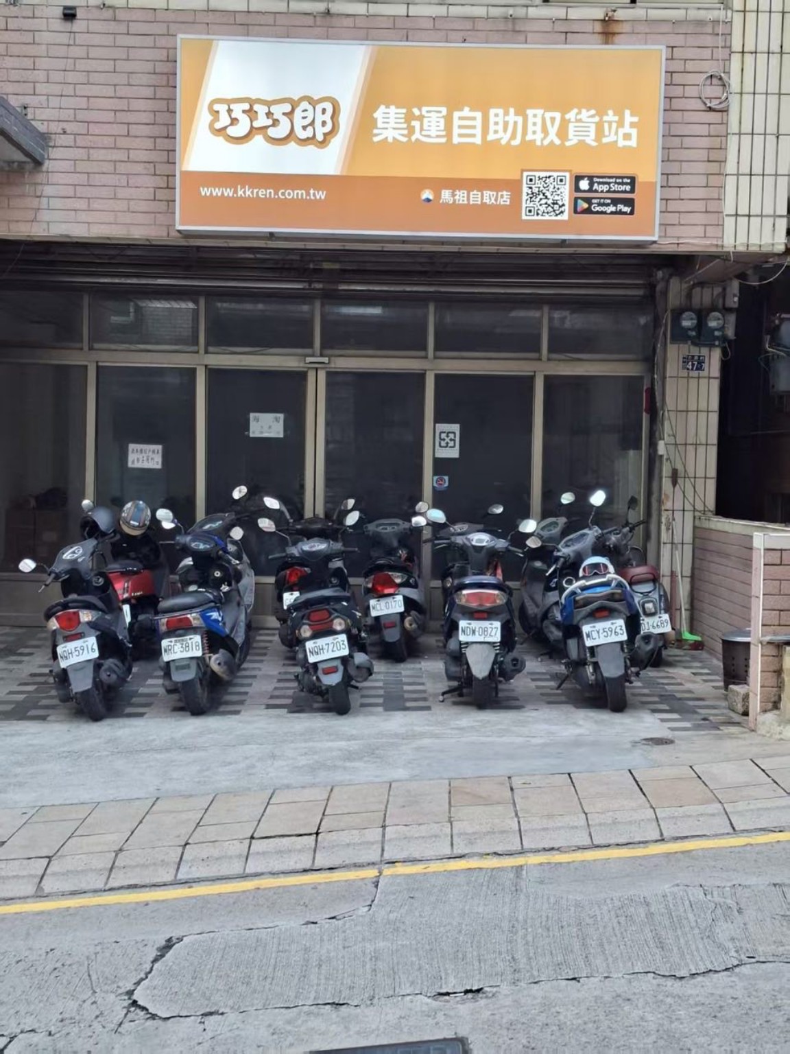 巧巧郎馬祖南竿自取店實景：黃色招牌、玻璃門入口與門前機車